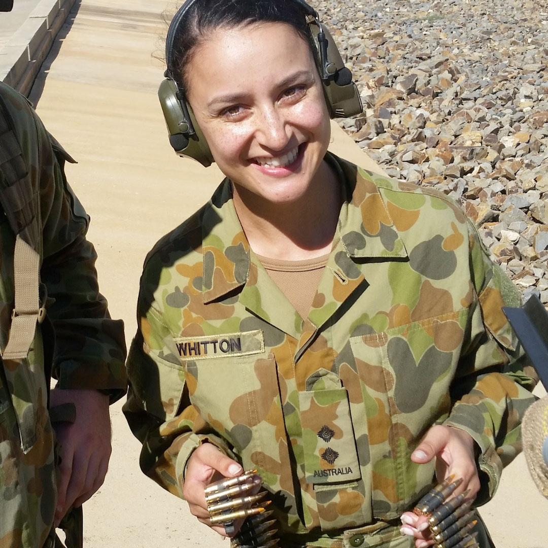 Larissa Whitton in ADF uniform holding a belt of ammunition